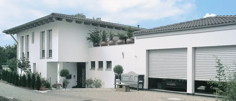 Dvojgaráž rodinného domu s bílými rolovacími vraty